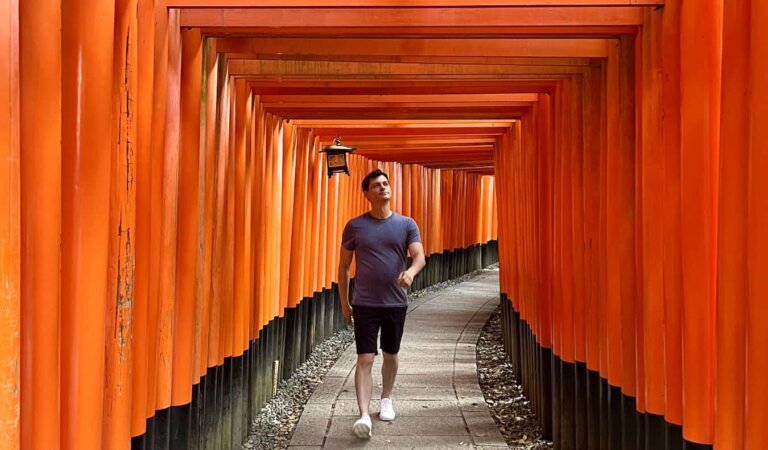Nomadic Matt walking under torii gates in historic Kyoto, Japan