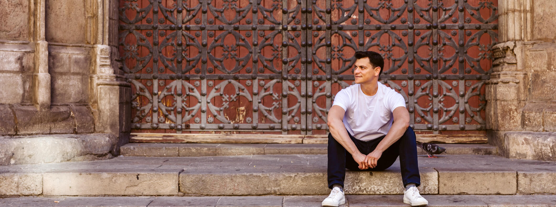 Nomadic Matt sitting on the stairs while posing in Barcelona, Spain