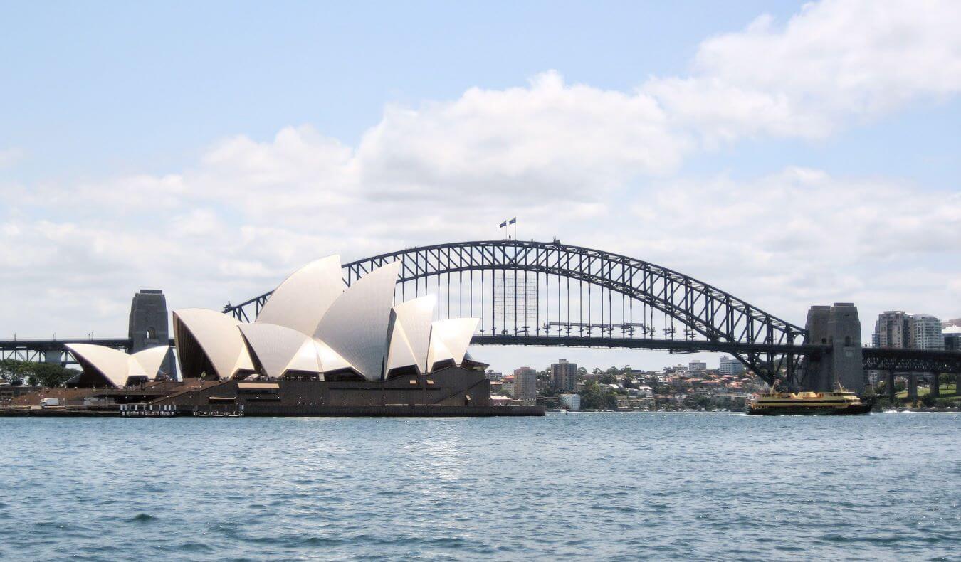 The skyline of Sydney, Australia as viewed from the water, with the famous Sydney Opera House and Sydney Harbour Bridge in full view