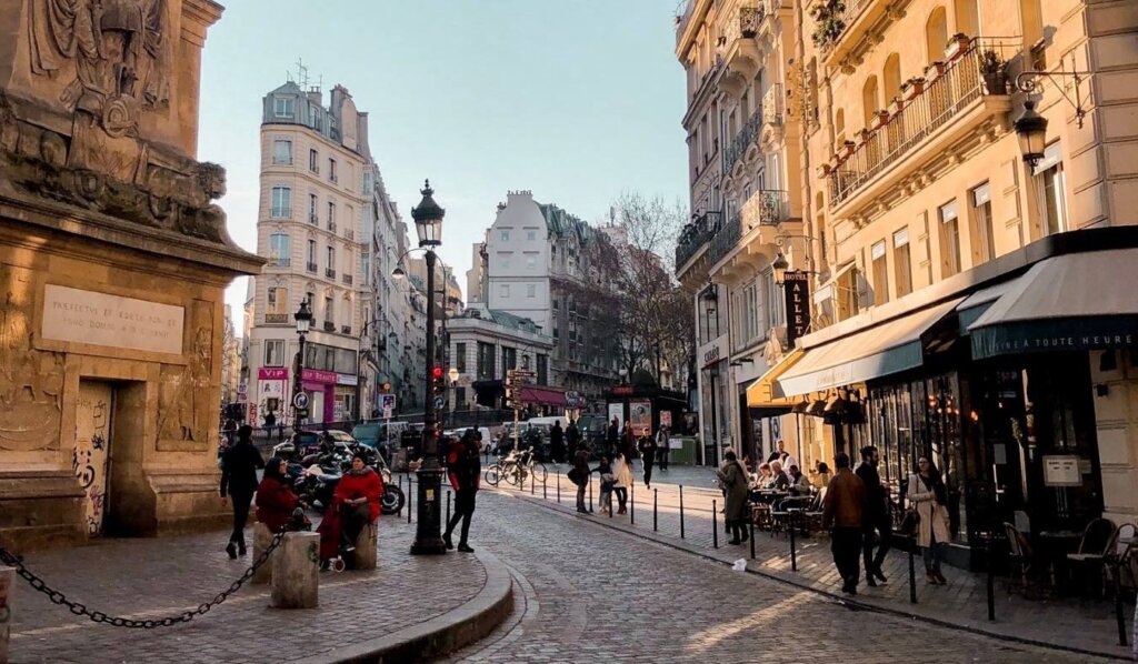 A winding street in Paris with golden light shining on the buildings
